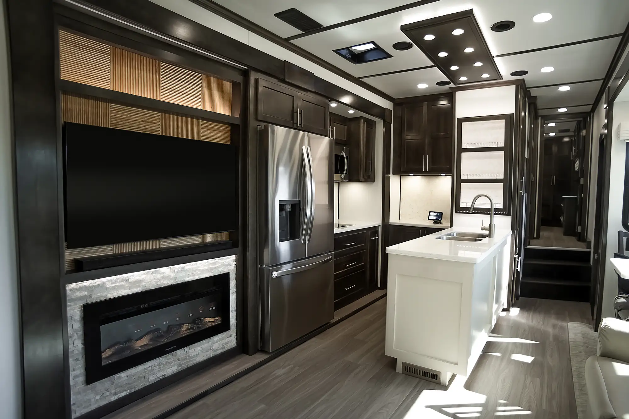 Brazilian Walnut cabinetry in the kitchen of a luxury fifth wheel made by Luxe Fifth Wheel.