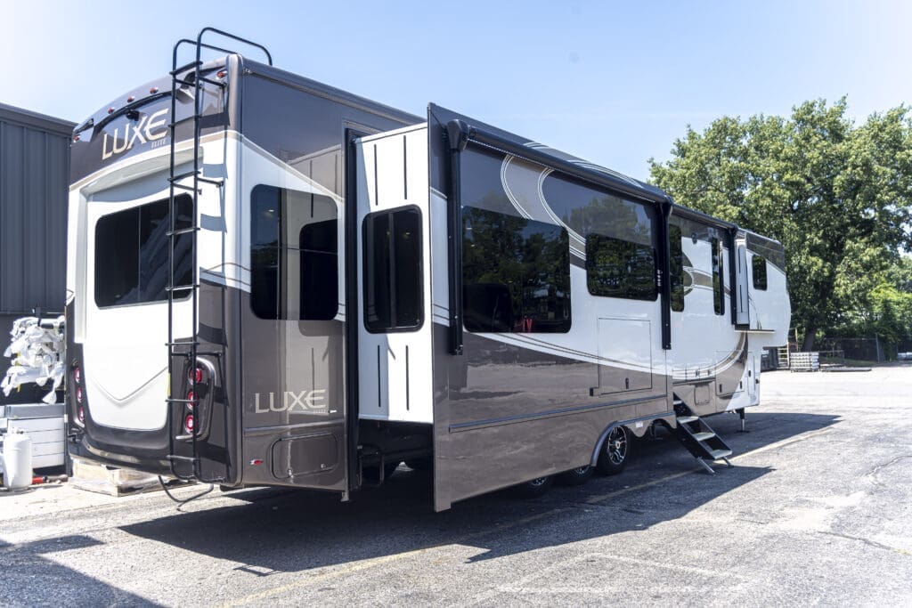 Luxe Elite 42MD luxury fifth wheel RV with slide-outs extended and rear ladder