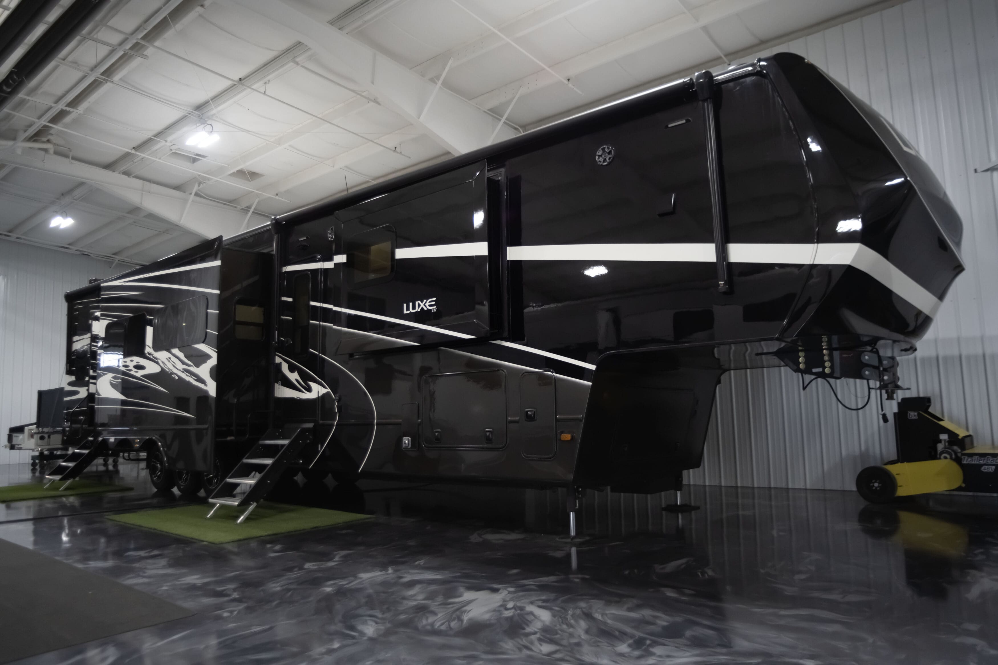 Luxe Toy Hauler 46FB luxury fifth wheel RV with black full-body paint and slide-outs