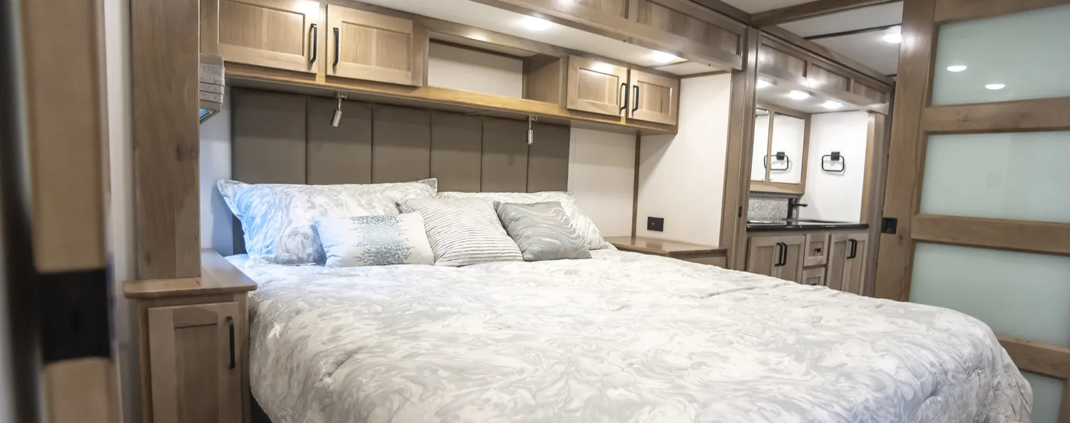 A comfortable bedroom in luxury fifth wheel built by Luxe Fifth Wheel.