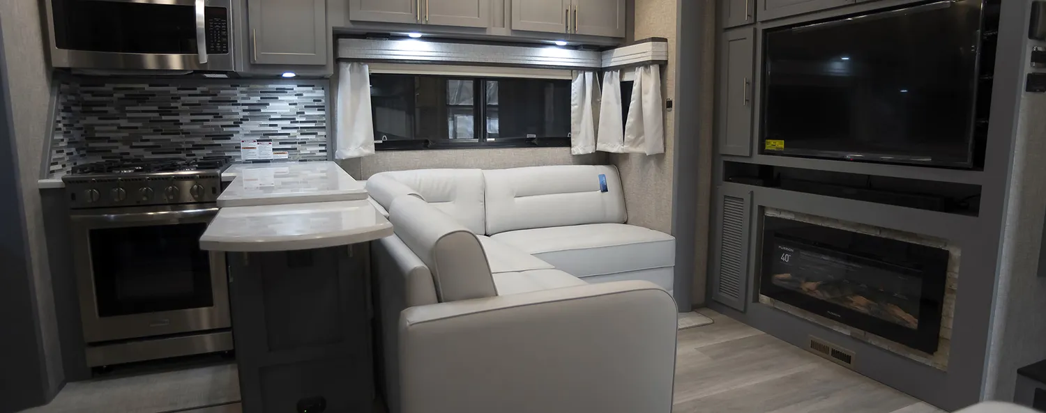 A spacious living Room in a luxury toy hauler fifth wheel, built by Luxe Fifth Wheel.