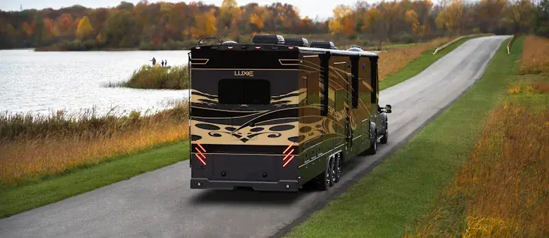 A Luxe Luxury Fifth Wheel Toy Hauler driving through a state park.
