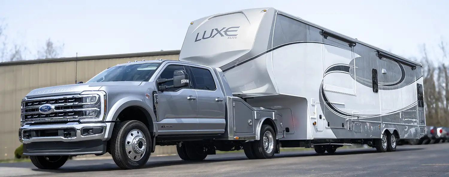 A Luxe Elite Luxury Fifth Wheel being hauled by a Luxe Truck Ford F550 with an all aluminum fifth wheel hauler bed.