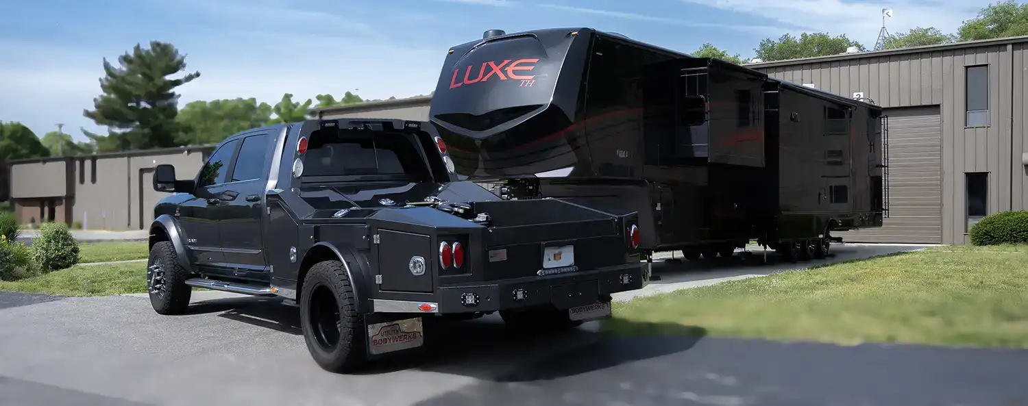 A Luxe Toy Hauler Luxury Fifth Wheel next to a Luxe Truck Ford F550 outside Luxe Fifth Wheel's showroom in Elkhart Indiana.