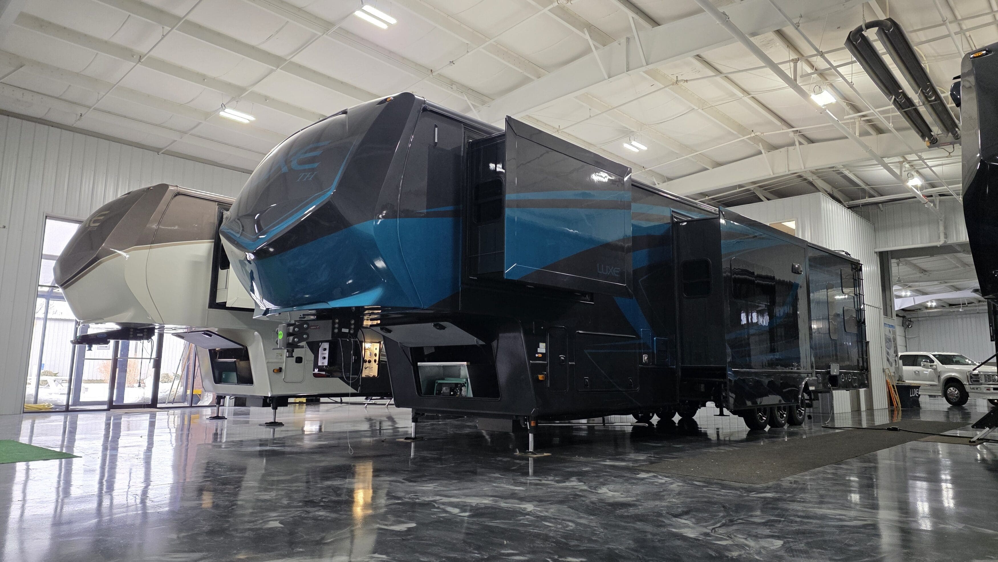 Luxe Toy Hauler 48FB luxury fifth wheel RV with blue full-body paint and slide-outs