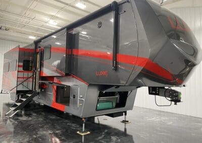 Luxe Toy Hauler 46FB luxury fifth wheel with full-body paint, red accents, and slide-outs