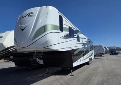 Luxe Regent and Gold luxury fifth wheel RVs with full-body paint and slide-outs under a clear sky
