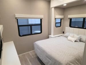 Luxe Elite luxury fifth wheel RV bedroom with large windows, king bed, and built-in storage for full-time living