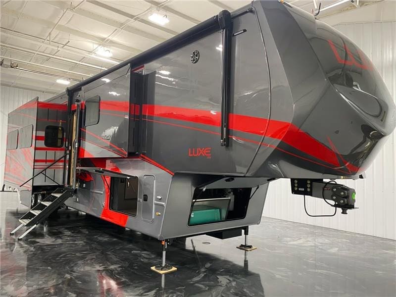image (10) Luxe Fifth Wheel Toy Hauler with red accents, slide-outs, and independent suspension